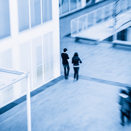 People walking in the business district, with skyscrapers.