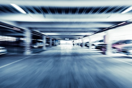Parking garage, interior with a few parked cars.Motion blur