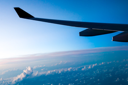Clouds and sky as seen through window of an aircraft at sunset