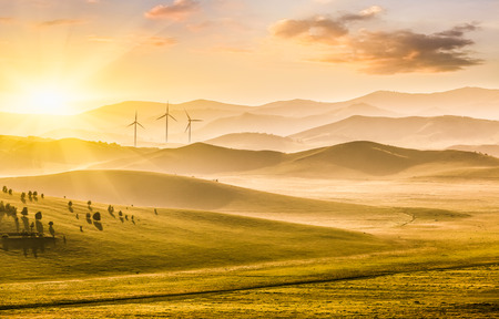 Mountains and grassland at sunsetの写真素材
