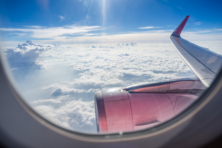 Clouds and sky as seen through window of an aircraftの写真素材