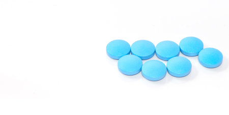 Close-up of blue round tablets on a white background, bannerの写真素材