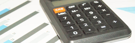 Calculator on a business chart showing financial success in the stock market, increased profits, bannerの写真素材