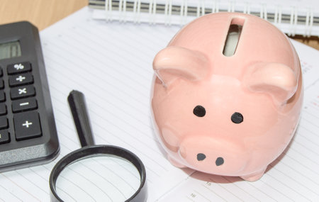 Piggy Bank, calculator, magnifying glass on the organizer for business planning. Business concept of saving financesの写真素材