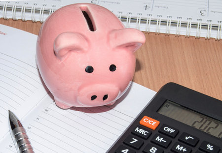 Piggy Bank, calculator and pen on the organizer for business planning. Business concept of saving financesの写真素材