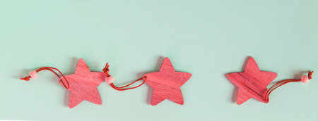 Christmas banner with three red wooden stars, decoration for the holiday in a rustic vintage style on a blue backgroundの写真素材