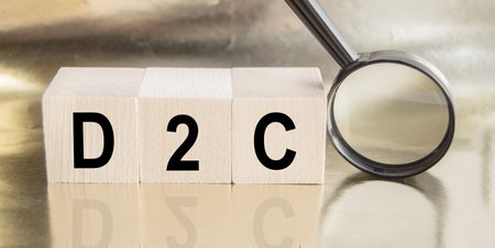 D2C word on wooden cubes, next to a magnifying glass, business concept of a startup and direct salesの写真素材