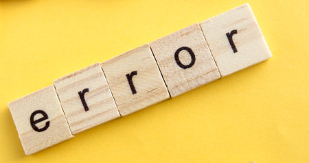 On the wooden blocks written ERROR, wooden blocks on a yellow background, top view, flat leyの写真素材