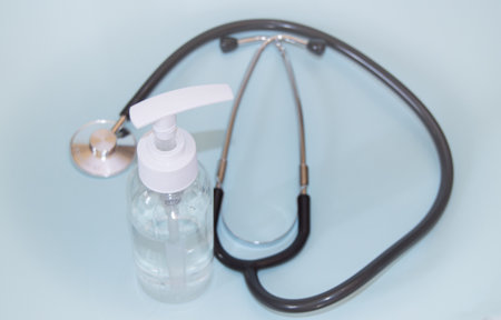 A bottle of disinfectant to disinfect from viruses, stethoscope on a blue background closeupの写真素材