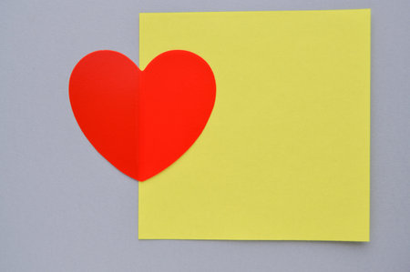 Valentines day greeting card with red heart on yellow and gray backgroundの写真素材