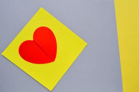 Valentines day greeting card with red heart on yellow and gray background