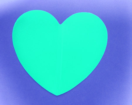 The concept of Valentines mockup, turquoise blank paper greeting card Valentine card in the shape of a heart on a purple paper backgroundの写真素材