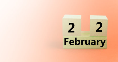 Perpetual wooden calendar made of wooden blocks with date February 22, reminder, planner on beige...