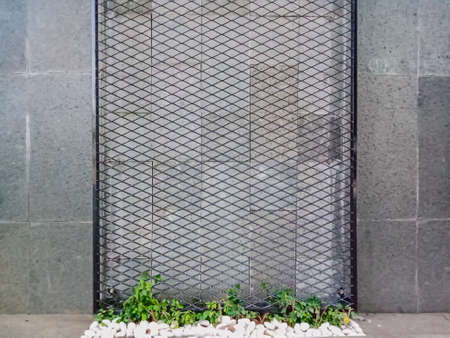 black metal trellis, with brick wall background.の写真素材