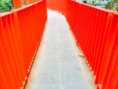 Orange iron railing on the bridge, with nature background.の写真素材