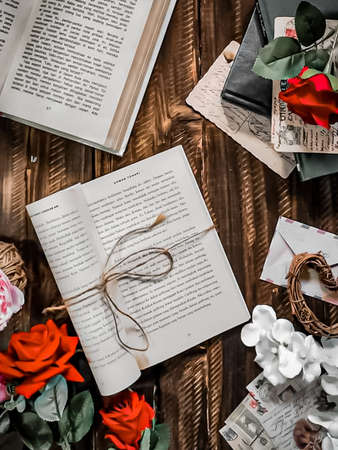top view of open book with blank pages, stationery and flowers on wooden backgroundの写真素材
