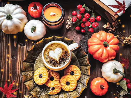 Autumn composition with leaves and cup of coffee, cake, pumpkin, candles on brown table, Still life concept.の写真素材