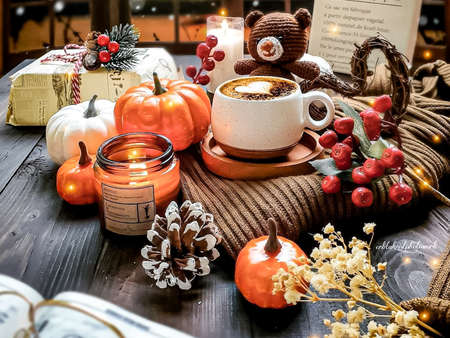 Cup of coffee with marshmallow and pumpkins on the wooden tableの写真素材