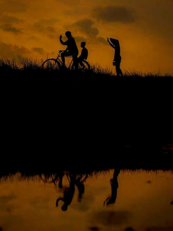 the beauty of the orange sunset seen above the rice fields.の写真素材