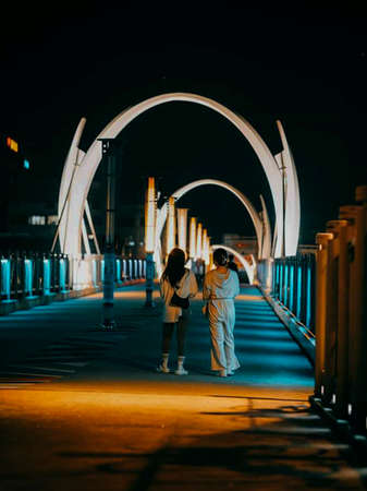 Couple in love walking on the bridge in the evening at nightの写真素材