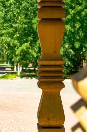 A carved wooden unpainted column on the porch of an old wooden Orthodox church. Side view.の写真素材