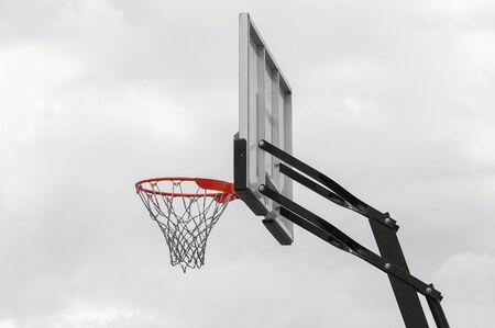 Basketball basket against the sky located outdoors in the street. View from below.