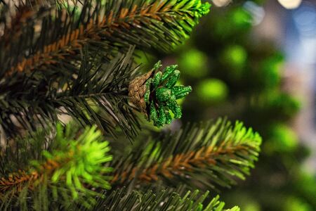 Green and glitter-covered natural bump on Christmas tree. Close up. Front view.の写真素材