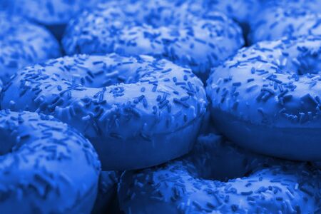 Lot of fresh donuts. Front view. Selective focus. Blue tinted.の写真素材