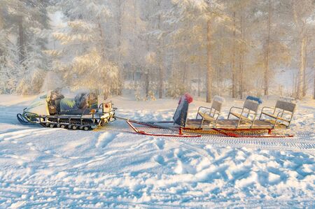 Snowmobile with sleigh in the winter forest. View from the side.の写真素材