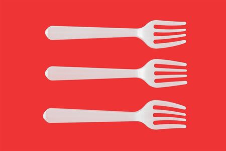 three plastic white forks on a red background