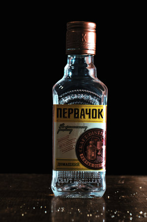 Small bottle of vodka On russianl anguageon text PERVACHOK a black background on a dirty table from bread crumbs. Surgut, Russia - 12 January 2021.のeditorial素材