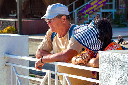 A man and a woman stand together in the summer. A sunny autumn day is a side view. Sudak, Crimea - 10 October 2020.のeditorial素材