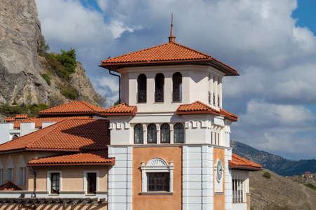 A house with a clock tower. Sunny summer day. Front view.