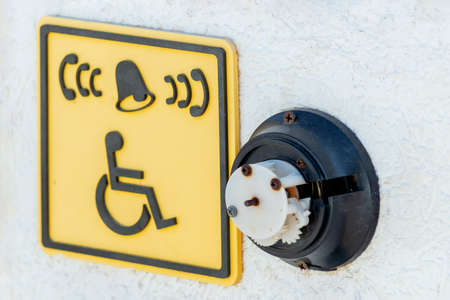 A broken call button for disabled people and a sign icon in front of the stairs to the beach of the sea.の写真素材