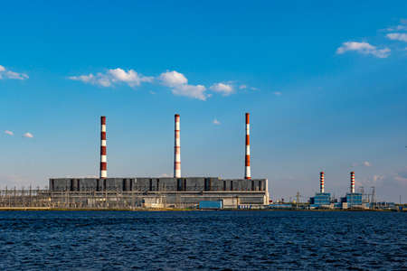 Hydroelectric power station operates and produces energy and electricity on shore of a reservoir in cityの写真素材