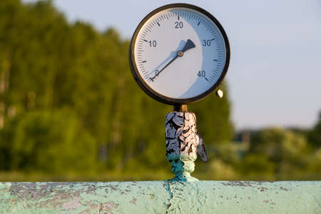Old pressure gauge on an old pipe.