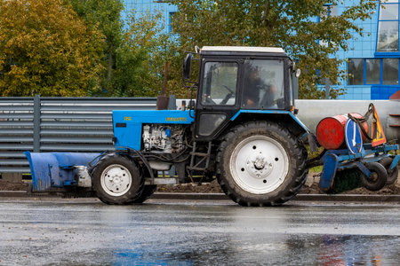 The tractor communal machine of blue color works. Bashkortostan, Russia - 19 June, 2022.