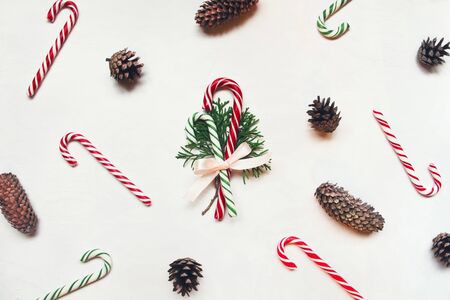 White wooden background with red and green christmas candies and conifer conesの写真素材
