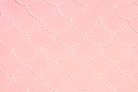 Lihgt pink ceramic tiles in the form of scales. Mosaic Tiles on the wall