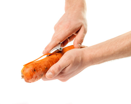 Hands carrots cleanse the skin with a knife .の写真素材