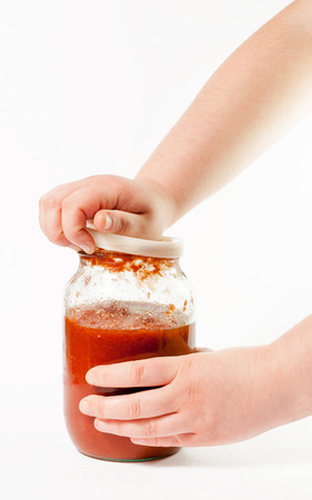 Man's hand opening a glass jar with pastaの写真素材