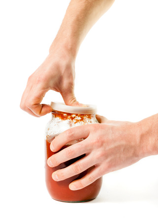 Man's hand opening a glass jar with pastaの写真素材