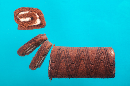 Chocolate roll on a turquoise background .の写真素材