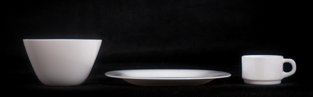 White plate with a mug on a black background .の写真素材