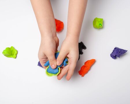 The hands of a little boy are making plasticineの写真素材