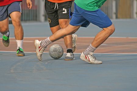 Player makes a tackle during a game of street football