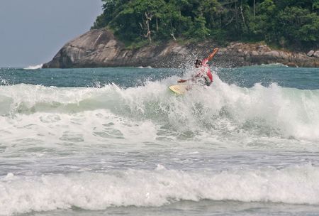 Surfer pulls a trick of a breaking wave in Phuket, Thailand