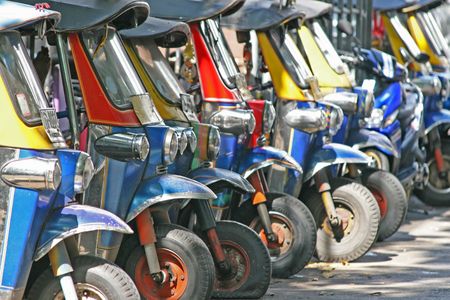 Tuk tuks lined up in a side ally in Bangkok