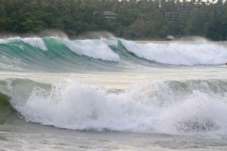 Large waves roll into a tropical beach in Phuket, Thailandの写真素材