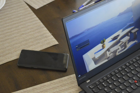Laptop and mobile phone on a wooden table with copy space.